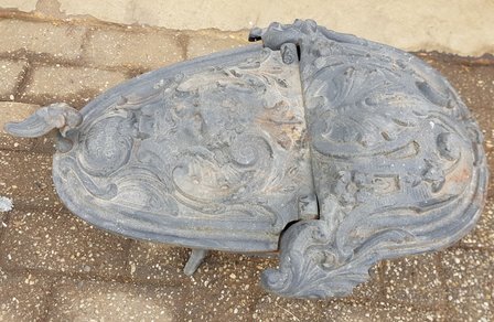 Antieke-oude-kolenbak-van-gietijzer-met-ornament-decoratie-met-een-hoofdAntieke-oude-kolenbak-van-gietijzer-met-ornament-decora