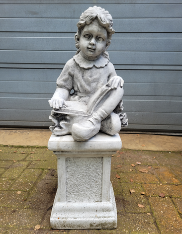 Betonnen-tuinbeeld-Kindje-meisje-die-een-boek-leest-op-voet-zuil-sokkel-beton