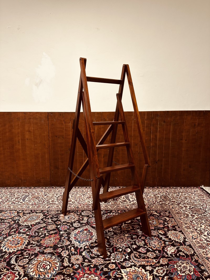 Een klassieke vrijstaande trap van mahoniehout voor een boekenkast