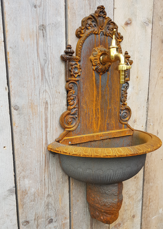 Gietijzeren wandfontein met messing kraan