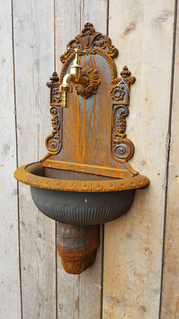 Gietijzeren wandfontein met messing kraan