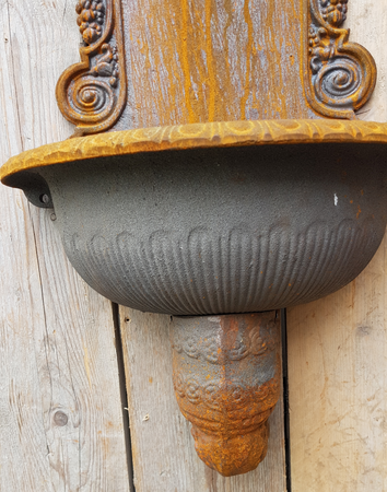 Gietijzeren wandfontein met messing kraan