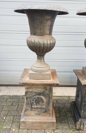 Antieke gietijzeren bloempot op sokkel